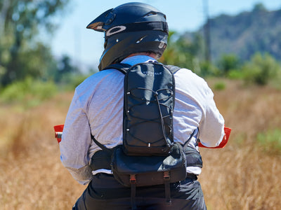 Rear view of the Clydesdale Gear Enduro Pack worn by rider sitting on his motorcycle showing how the weight is carries on your hips not your shoulders for a more comfortable ride.